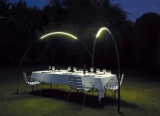 Jardín con mesa para cenar bajo dos lámparas Halley.