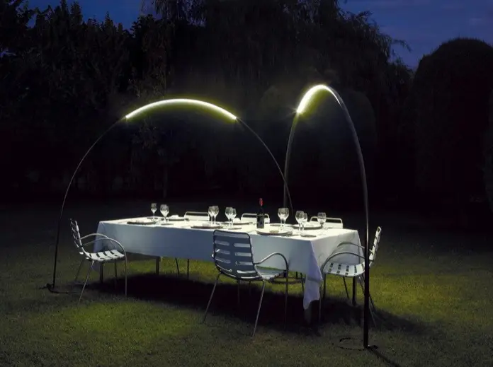 Jardín con mesa para cenar bajo dos lámparas Halley.