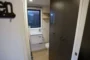 Puerta corredera abierta entre la cocina y el cuarto de baño.