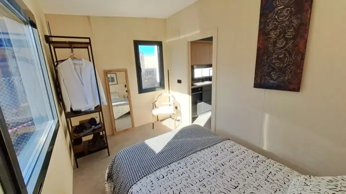 Dormitorio con cama grande y puerta corredera, en la casa Kyabin