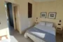 Dormitorio de la vivienda Kyabin, con la cama hecha y puerta abierta